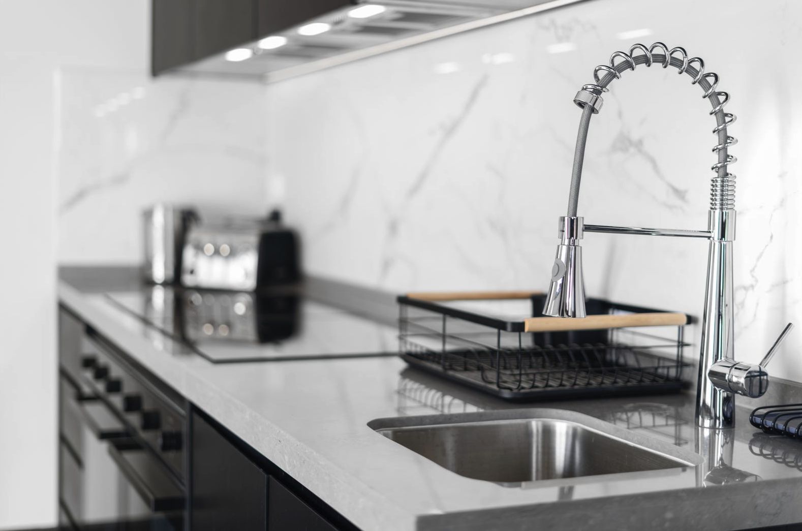 Stone benchtop, undermount sink and chrome mixer in a Harmony kitchen